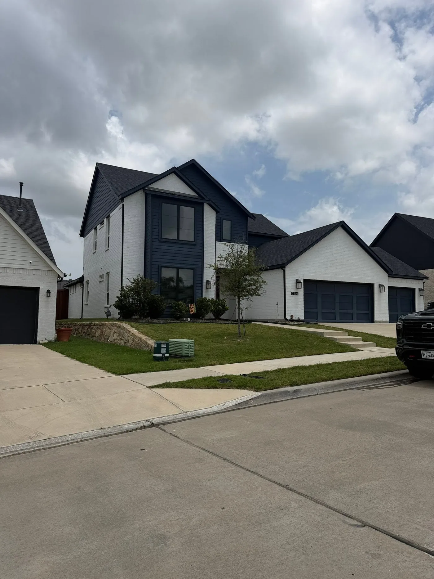Modern two-story white and navy home with new dark architectural shingle roof
